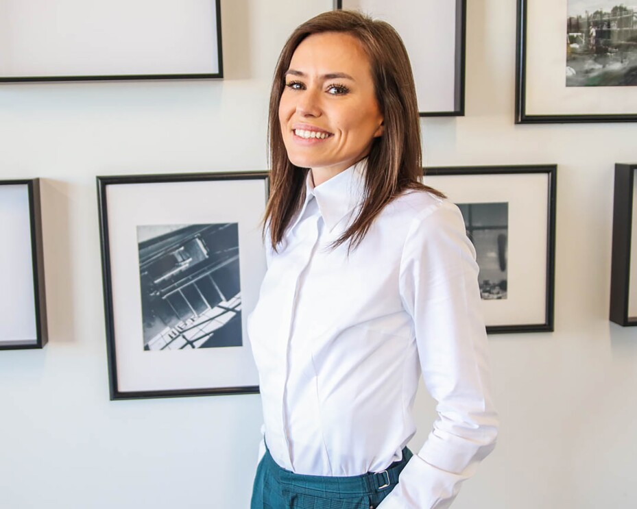 A woman looks at the camera in a general home environment.