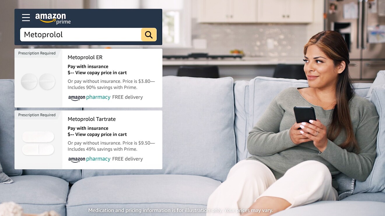 A woman sits on a couch with her mobile phone to look up what medications are available on Amazon Pharmacy. 