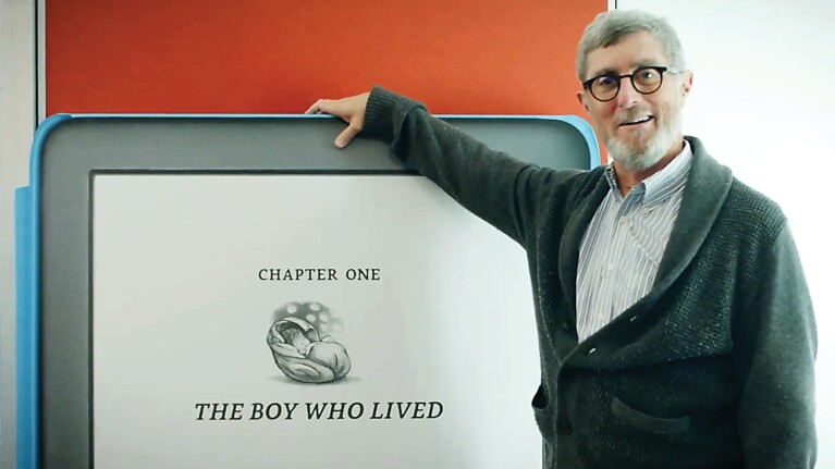 An image of Kindle fan Len Edgerly standing next to a Kindle sign.