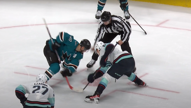 冰球运动员在冰上对峙的画面。