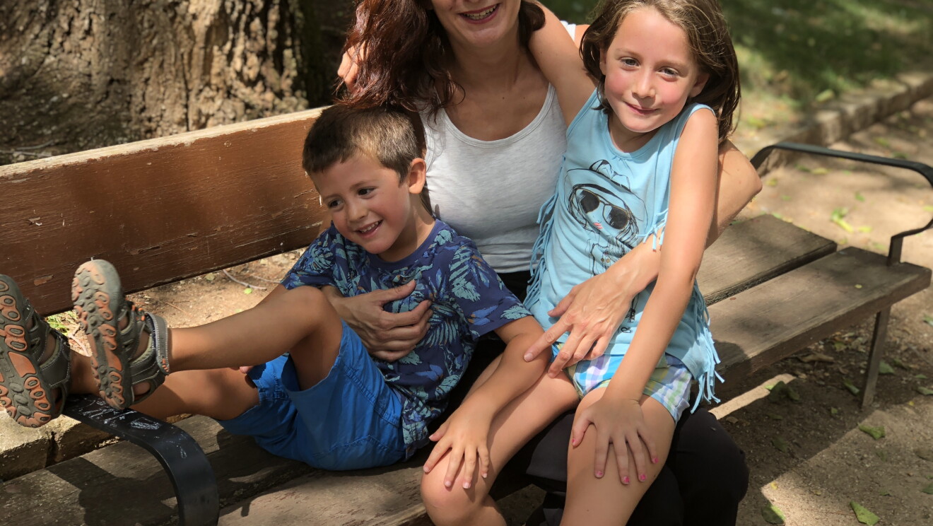 Irene, creadora de Andone Dynamic Walks aparece sentada en un banco de un parque agarrando a sus dos hijos: Lola, la hija mayor, y Alex, el menor. Los tres miran a cámara y sonríen. 