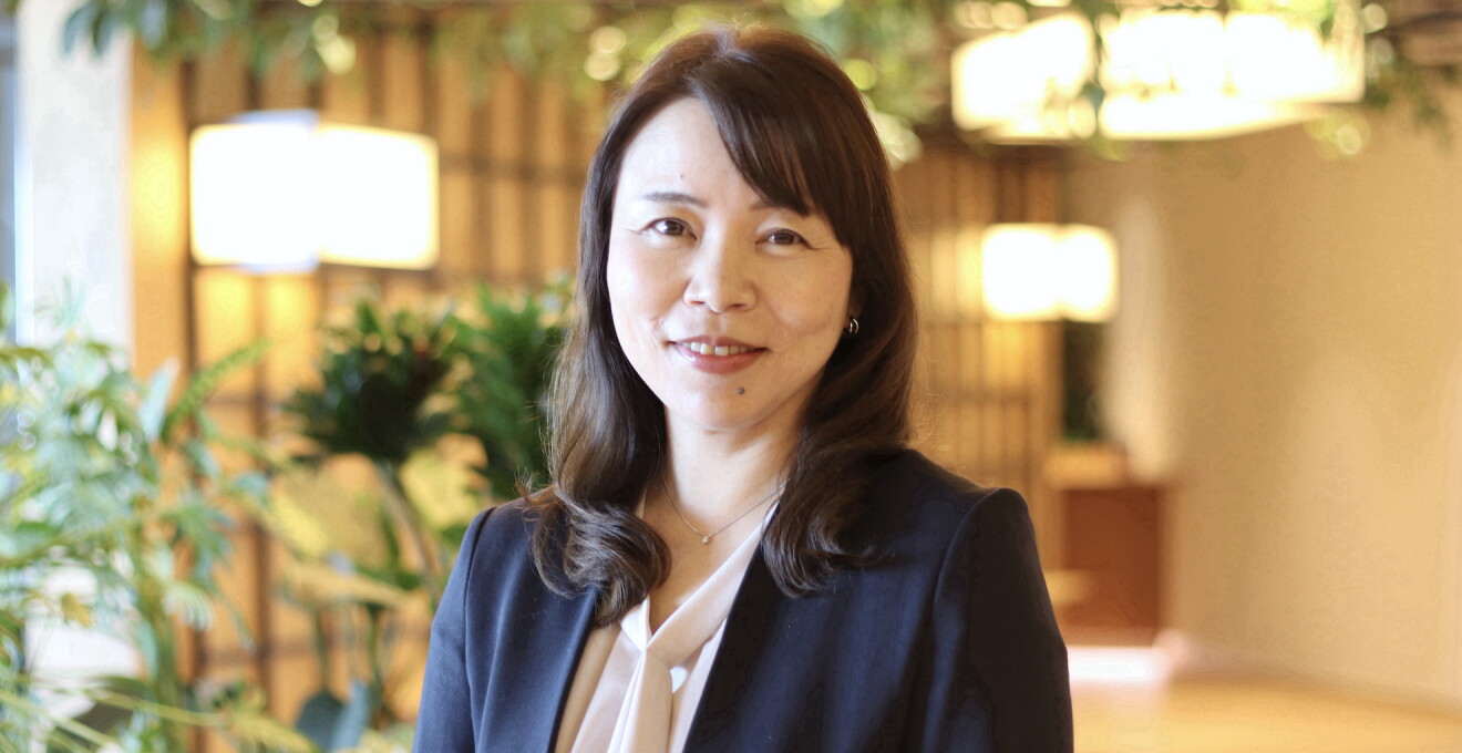 明るいインテリアの前に立つロングヘア―の女性。節約アドバイザーの和田由貴さん