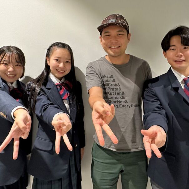 Japanese YouTuber Ghib Ojisan and Japanese high school students giving the peace sign in the AWS Singapore office.