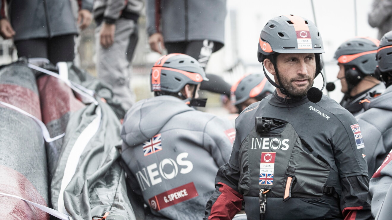 The INEOS Team UK team in their branded sailing gear.  Sir Ben Ainslie, who leads the team is a the front of the picture. 