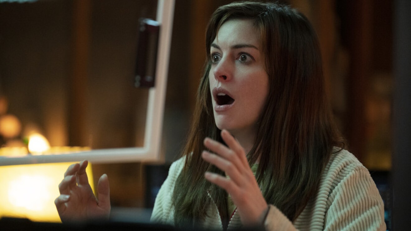 An image of Anne Hathaway looking shocked and surprised with her hands raised in front of her.