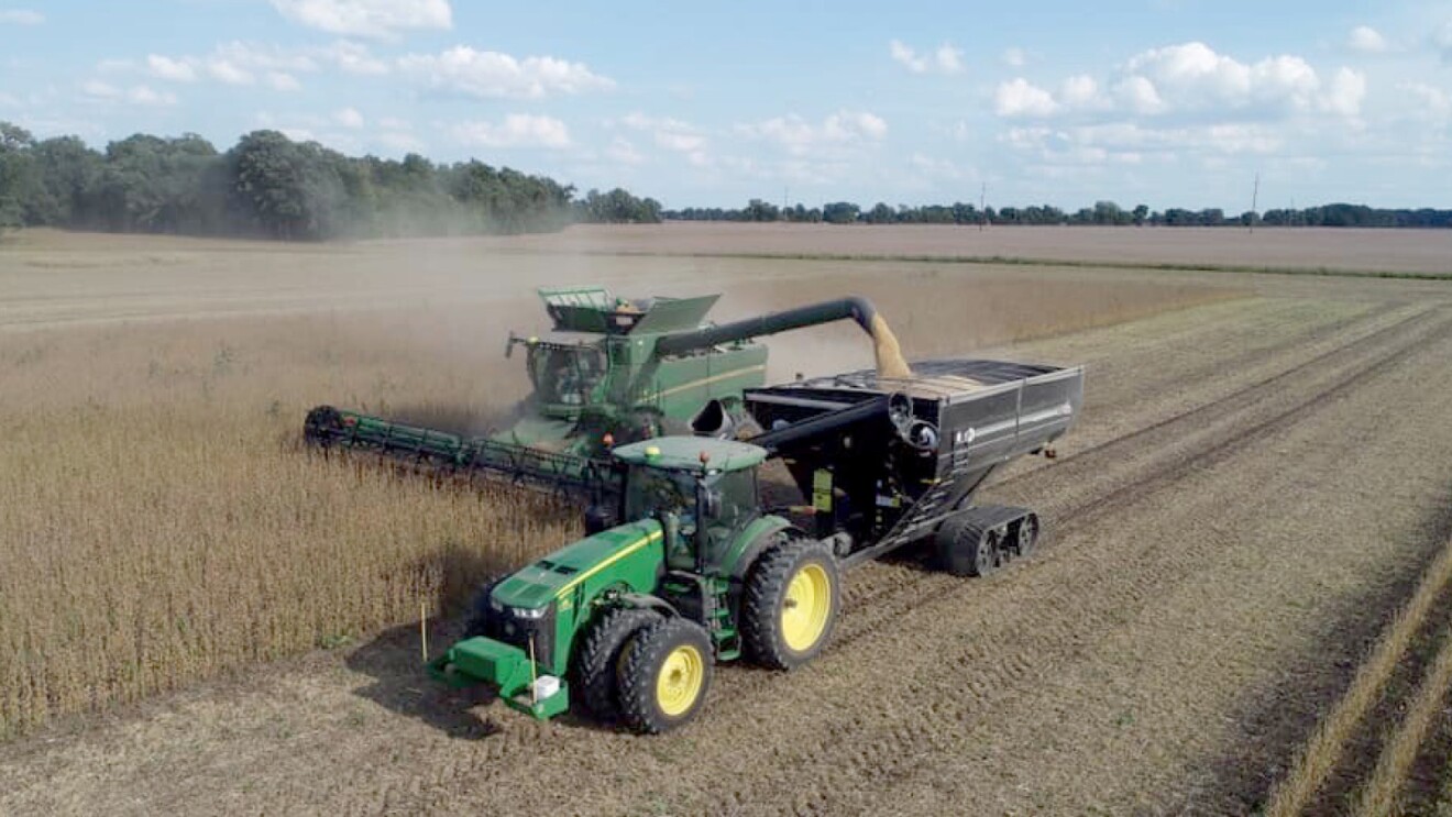 A photo of a tractor collecting grain from a field.