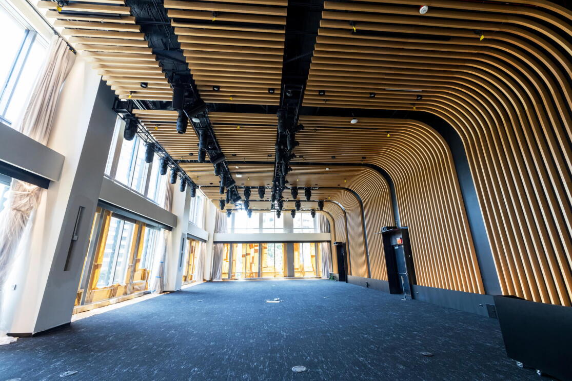The second event space at Amazon's headquarters in Arlington, VA. There is blue carpet and a large room with big, tall windows.