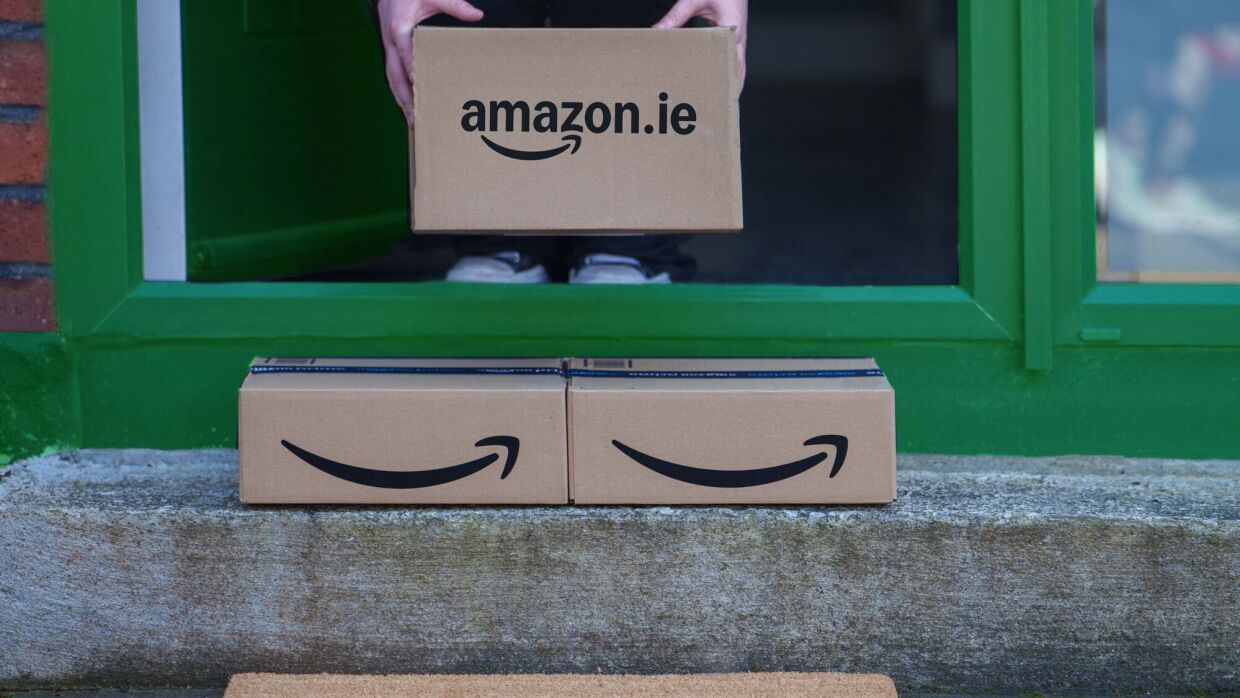 Hands holding Amazon.ie box above doorway