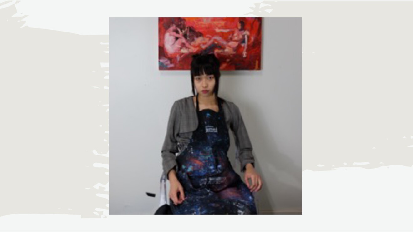 A photo of artist Yongqi Tang sitting in front of a painting.