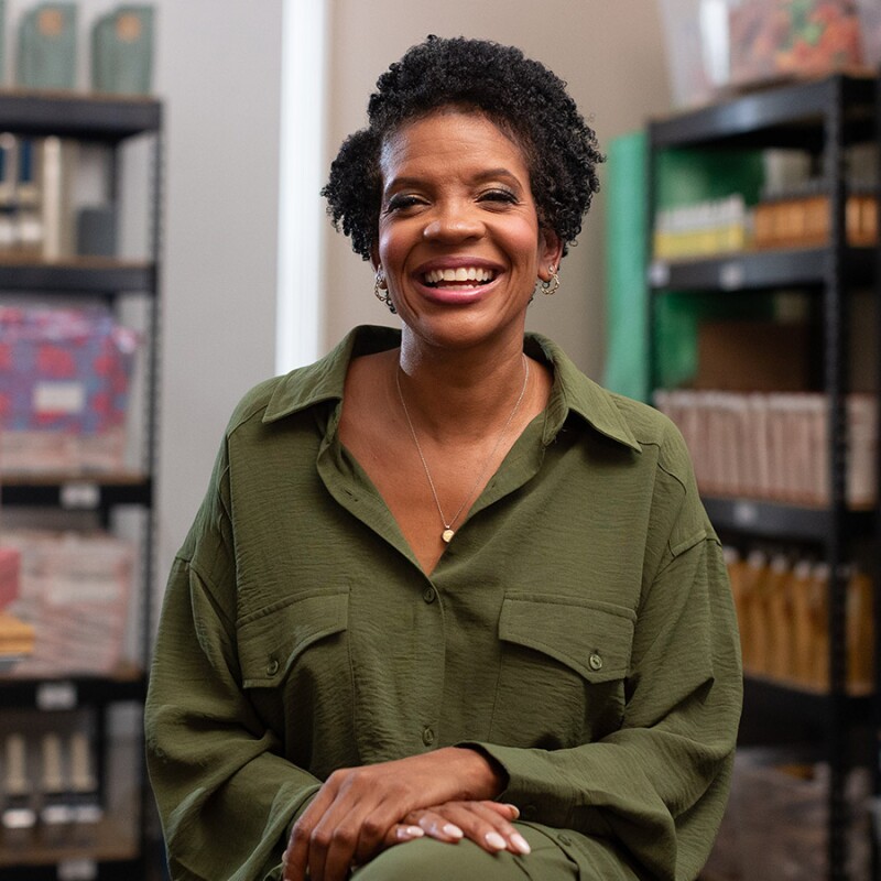 Radiant businesswoman in casual attire inside small shop