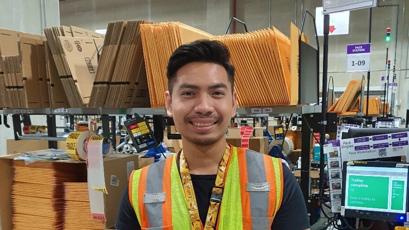 Aung Kaing giving a thumbs up in the fulfillment centre in Singapore