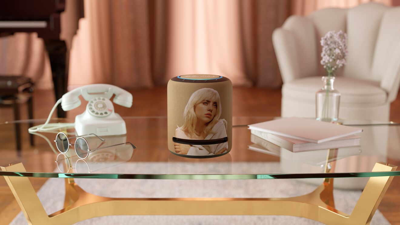 比利Eilish限量版回波工作室坐落在一个咖啡桌旁边的电话、太阳镜、书籍和花在花瓶里。