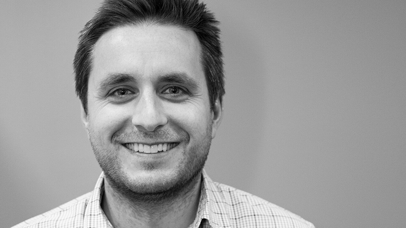 儿童作家迈克·派特里克的肖像。他在一个中性的背景前穿着一件格子衬衫。