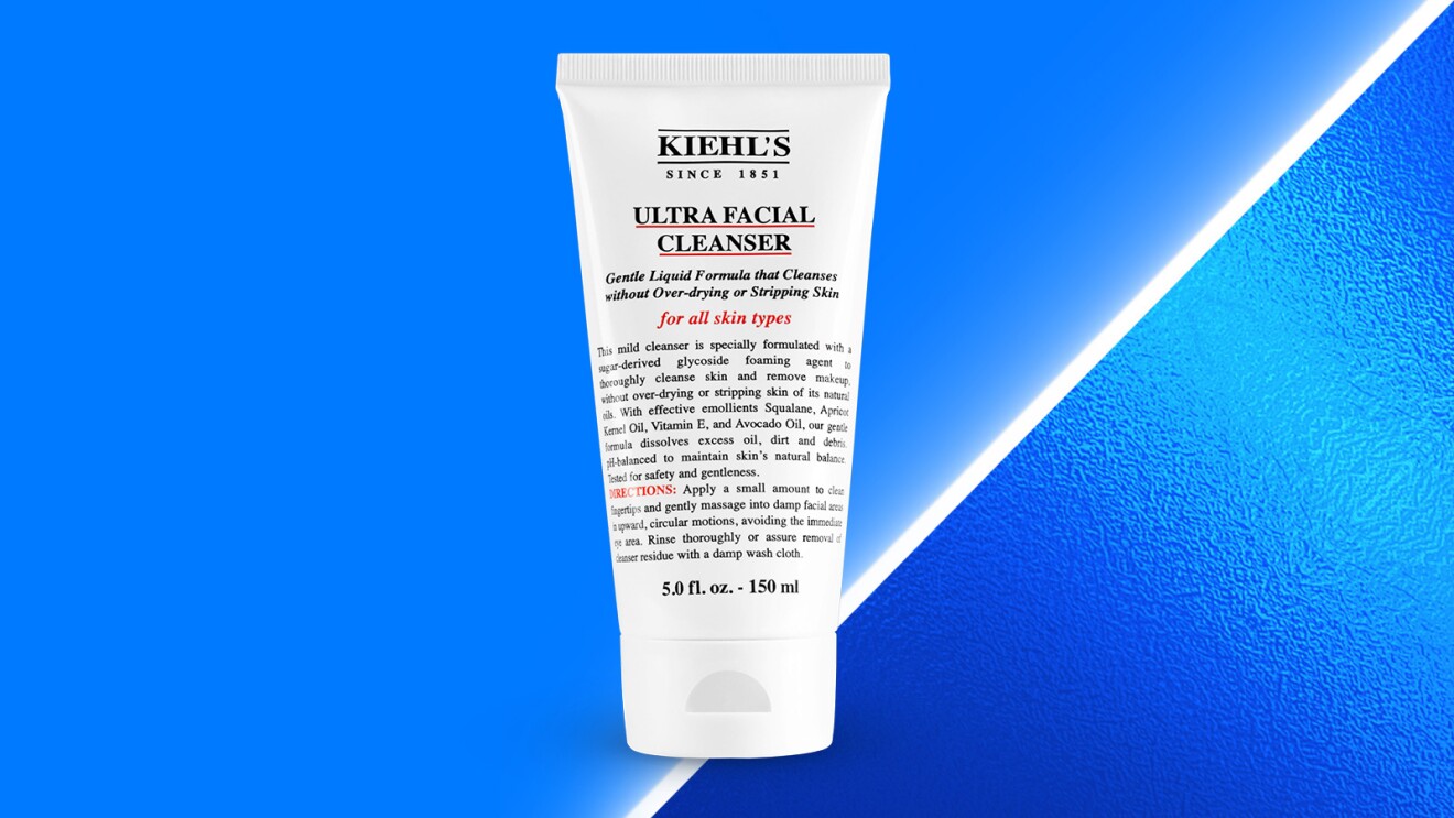 White bottle of Kiehl's facial cleanser against vibrant blue