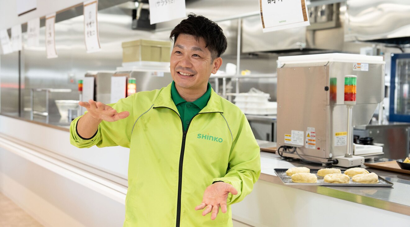 食堂の前で話をする男性