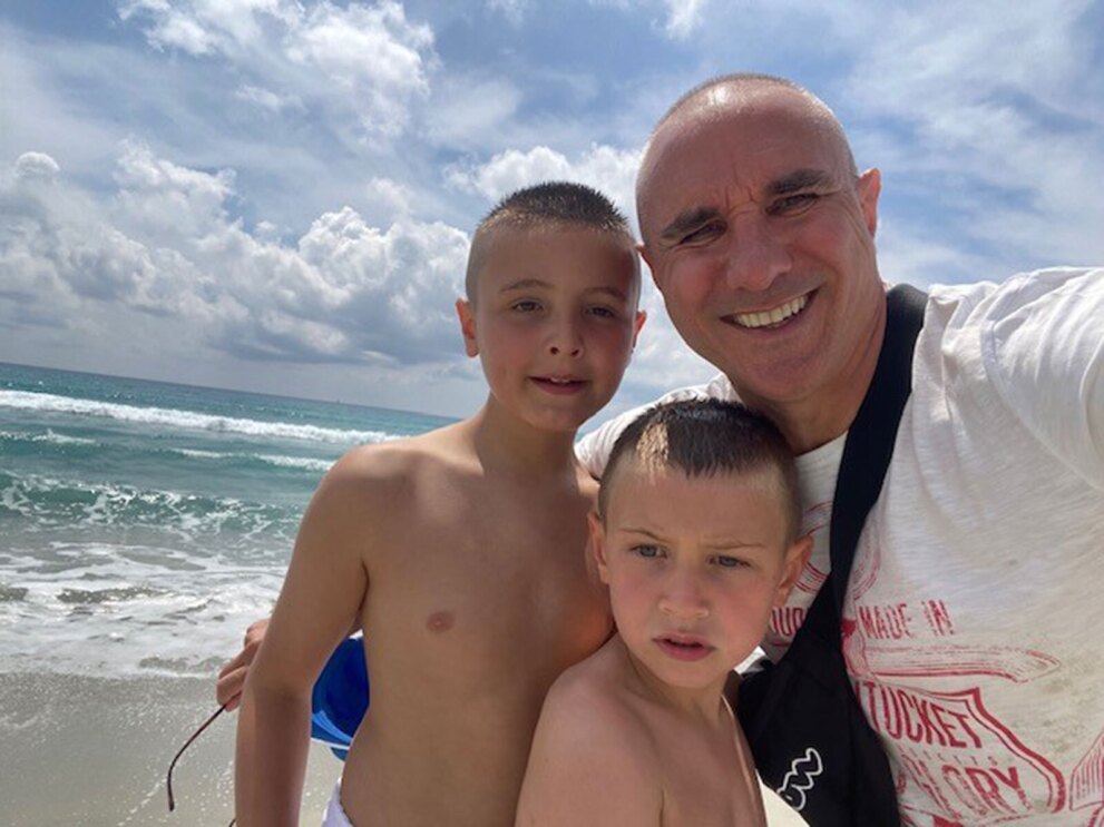 An image of Stefano Perego with his two young sons at the beach