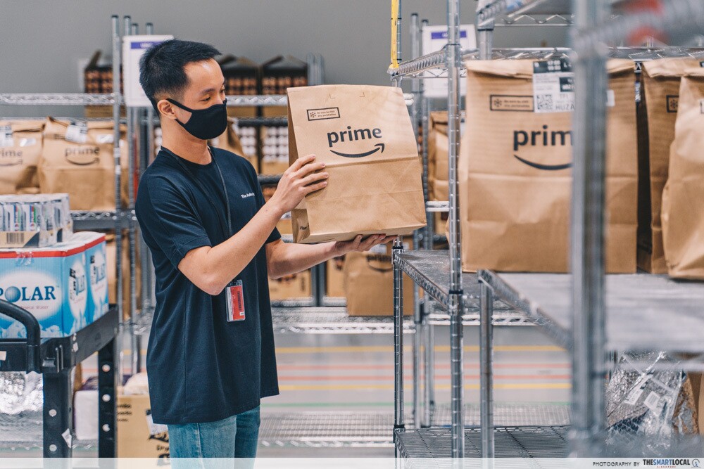 An employee placing orders onto shelves, ready for pick up by delivery drivers