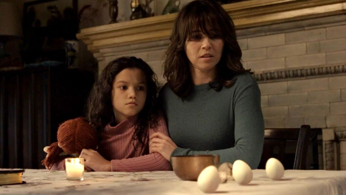 The Conjuring movie: Woman and young girl at table with candle and eggs