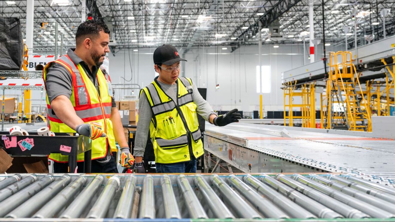 Safety-equipped personnel inspecting warehouse machinery