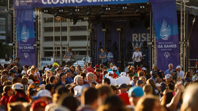 2018年美国特殊奥林匹克运动会闭幕式阶段。西雅图乐队“嘿马赛”执行(在照片中,一名歌手,贝斯手,键盘手和电动吉他手),与一群人在舞台的前面。