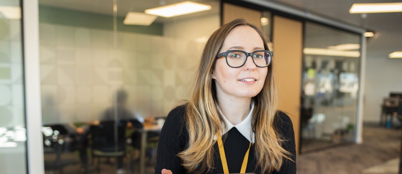 Female employee wearing glasses and sat in an Amazon office