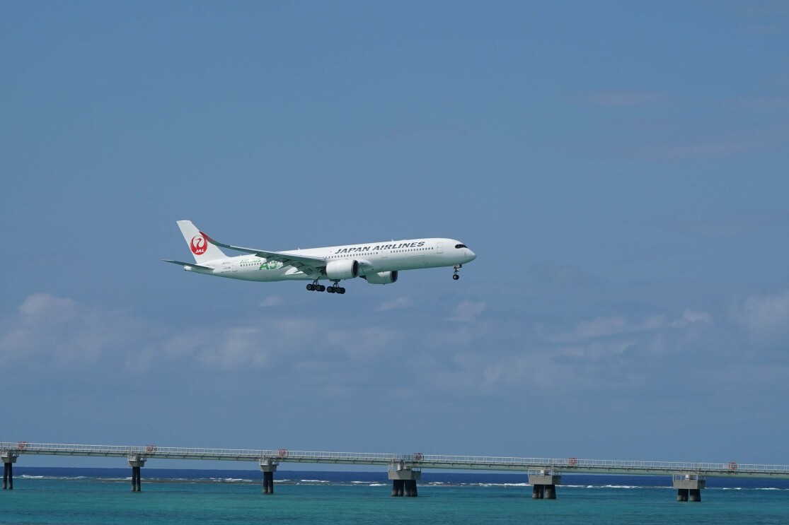 沖縄の海の上を飛ぶジェット飛行機