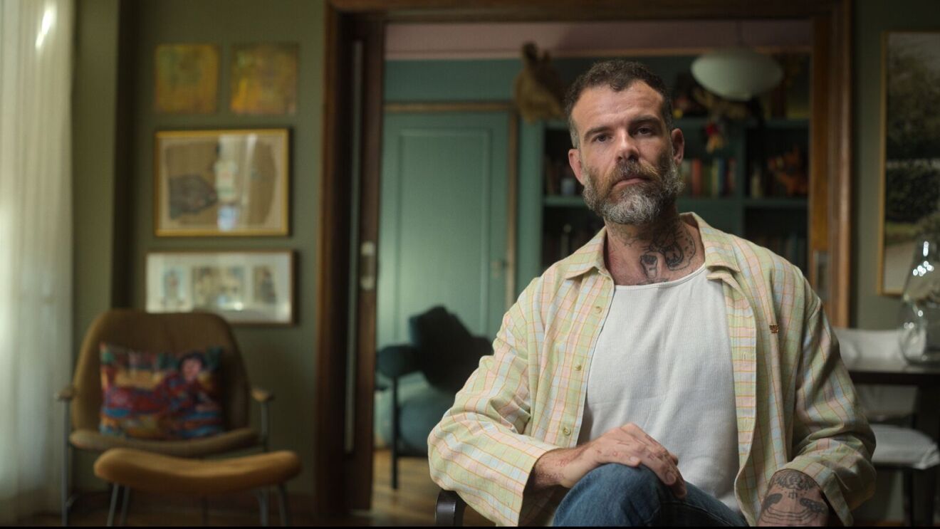 A bearded man looks into the camera