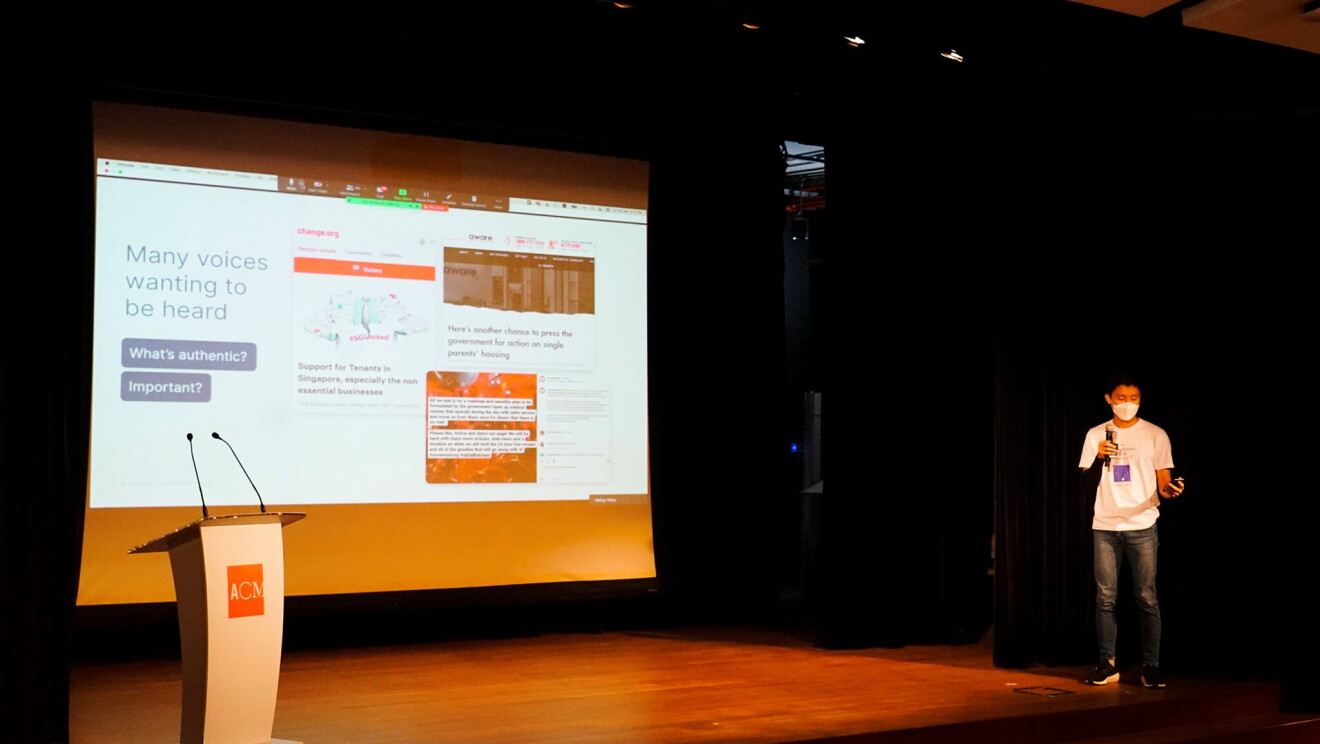A man in jeans presenting on a stage.