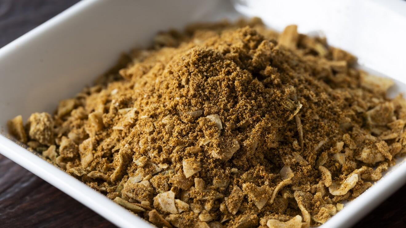 茶色いスパイスの粉。粒状のものがまざっている