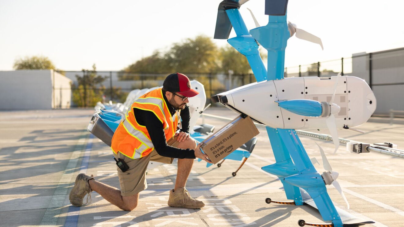Amazon drone operator loading parcel onto Prime Air delivery drone