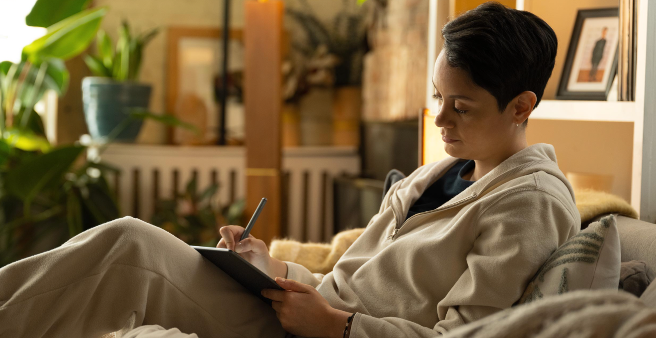 リビングでKindle Scribeに何か書き込みをしている女性