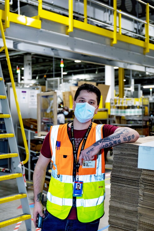 LCY2 - David Gonzalez wearing a facemask and hi-vis jacket in a fulfilment centre