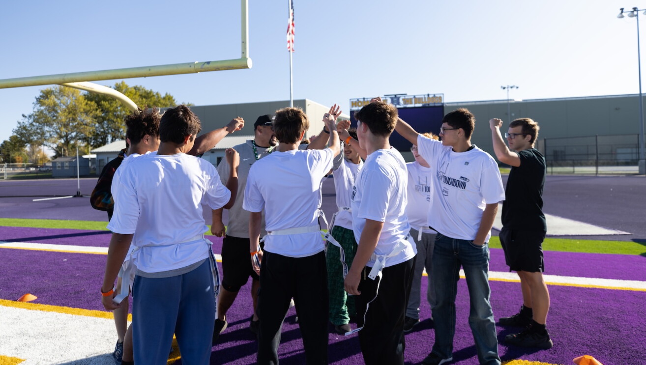 Hermiston students go hands in on the football field at Tech Touchdown.