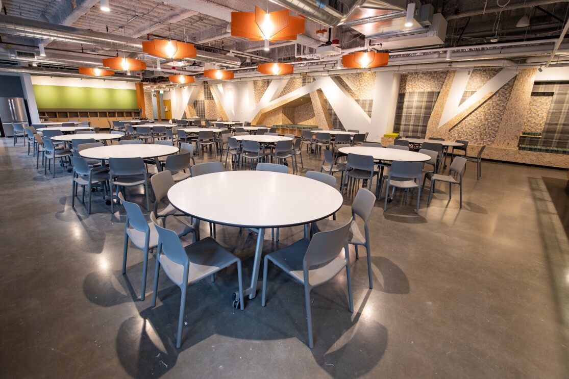 An image of a room with tables where families can eat together and enjoy a view of the city of Seattle.