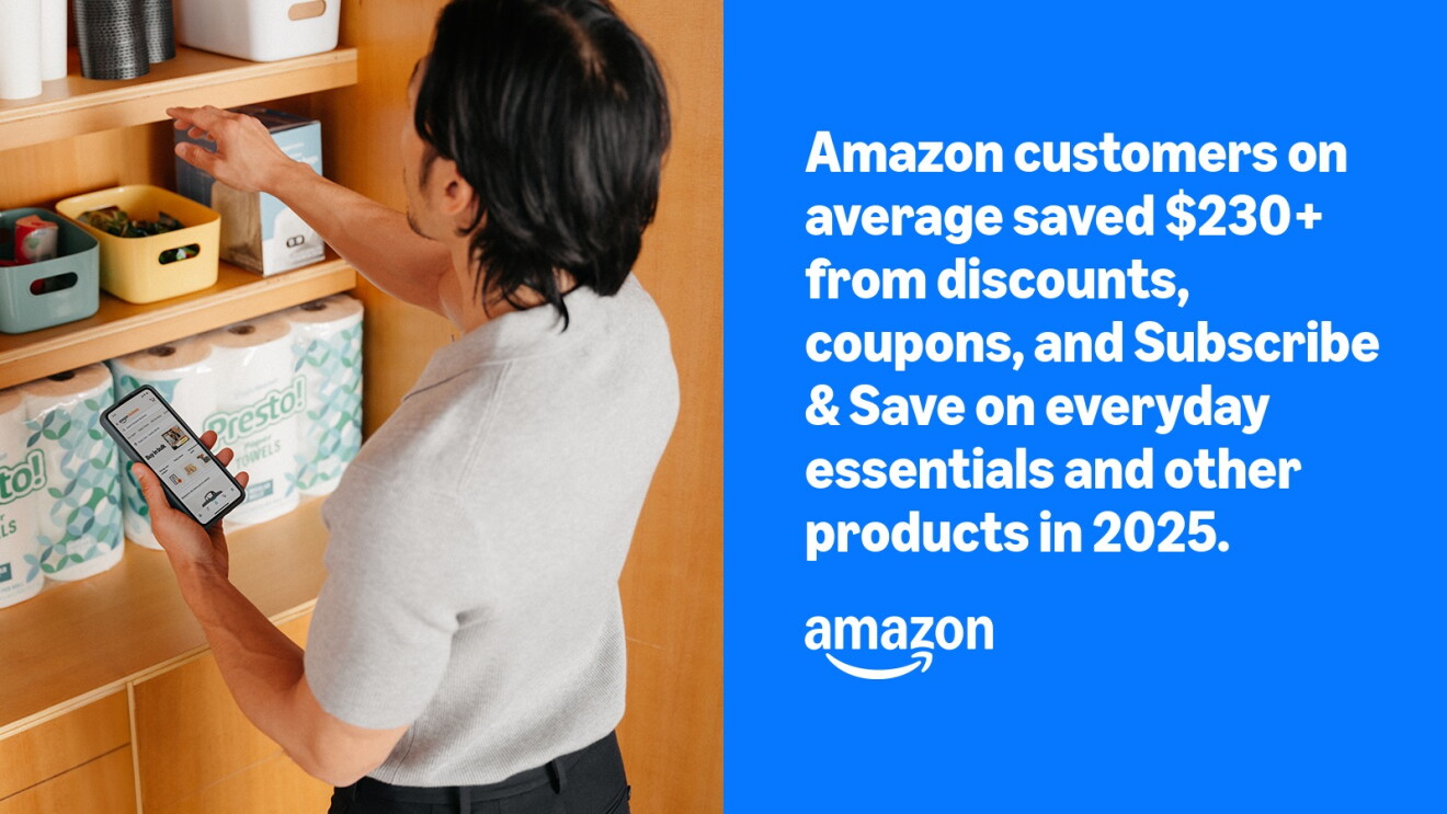 Person checking phone while organizing pantry shelf with paper towels and storage bins