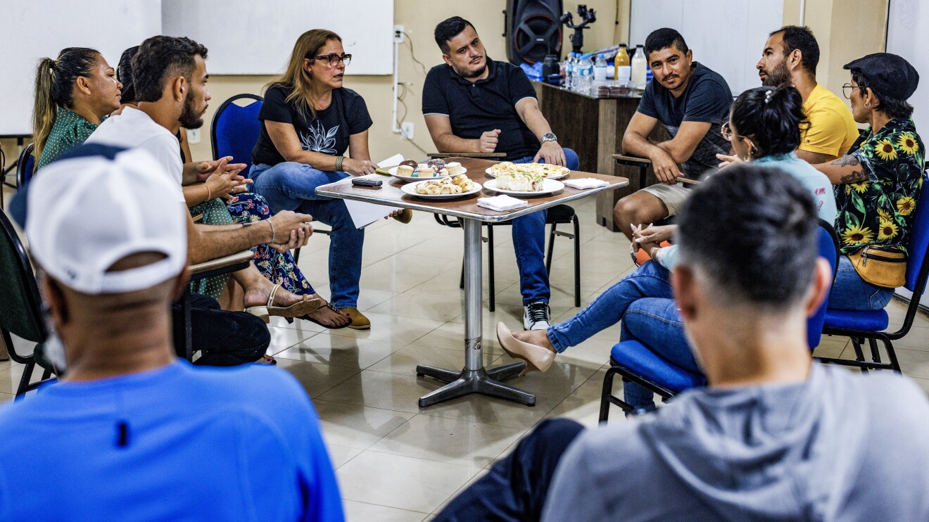 Grupo de personas debatiendo alrededor de una mesa. 