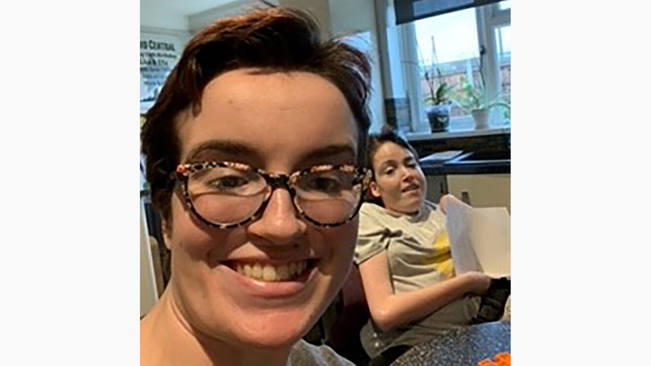 Ella and Lisa smiling at the camera at home.