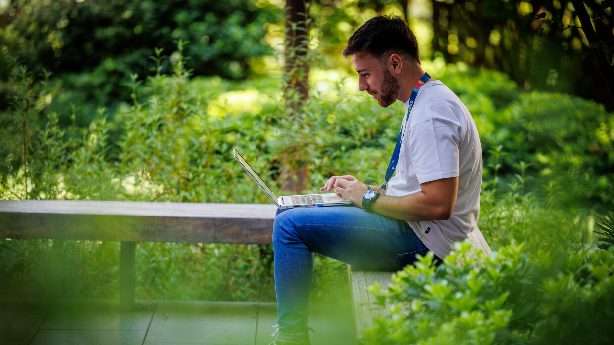 Un hombre trabajando con un ordenador en el jardin de una oficina logística de Amazon en Madrid. 