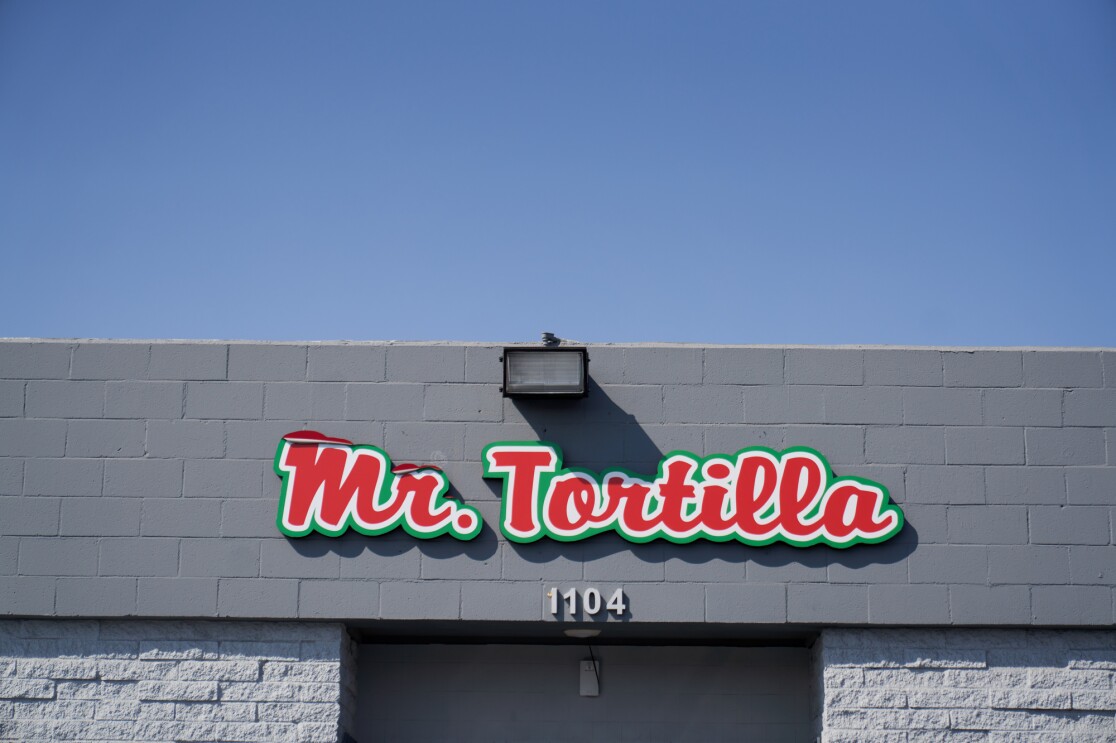 一个红色的Mr. Tortilla标志悬挂在Mr. Tortilla仓库的门上。