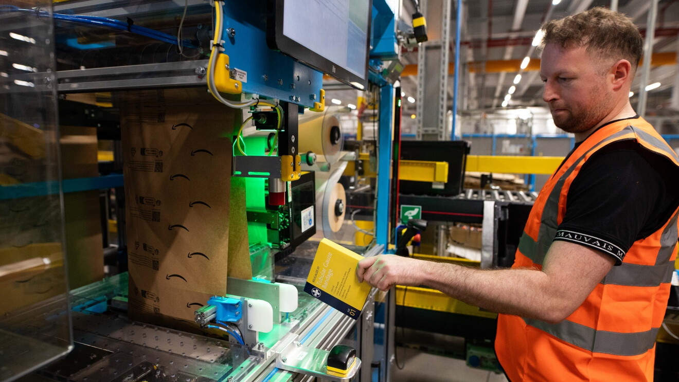 Umweltfreundlichere Verpackung bei Amazon: Foto der Maschine und einem Mitarbeiter, der mit der Maschine arbeitet.