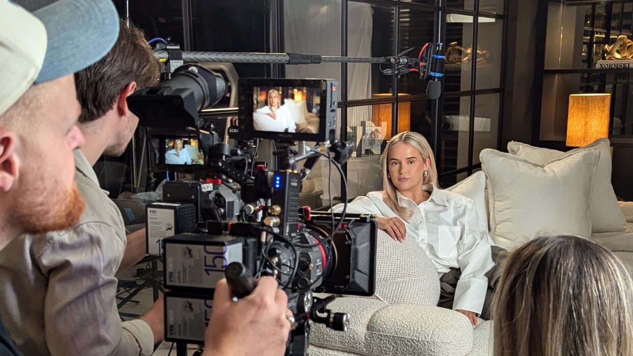 Film crew recording interview with Molly Mae on white couch
