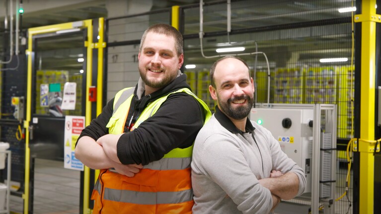 Dennis mit Kolleginnen und Kollegen an seinem Arbeitsort, dem Amazon Logistikzentrum in Oelde.