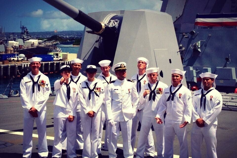 10 members of the U.S. Navy, pose together.