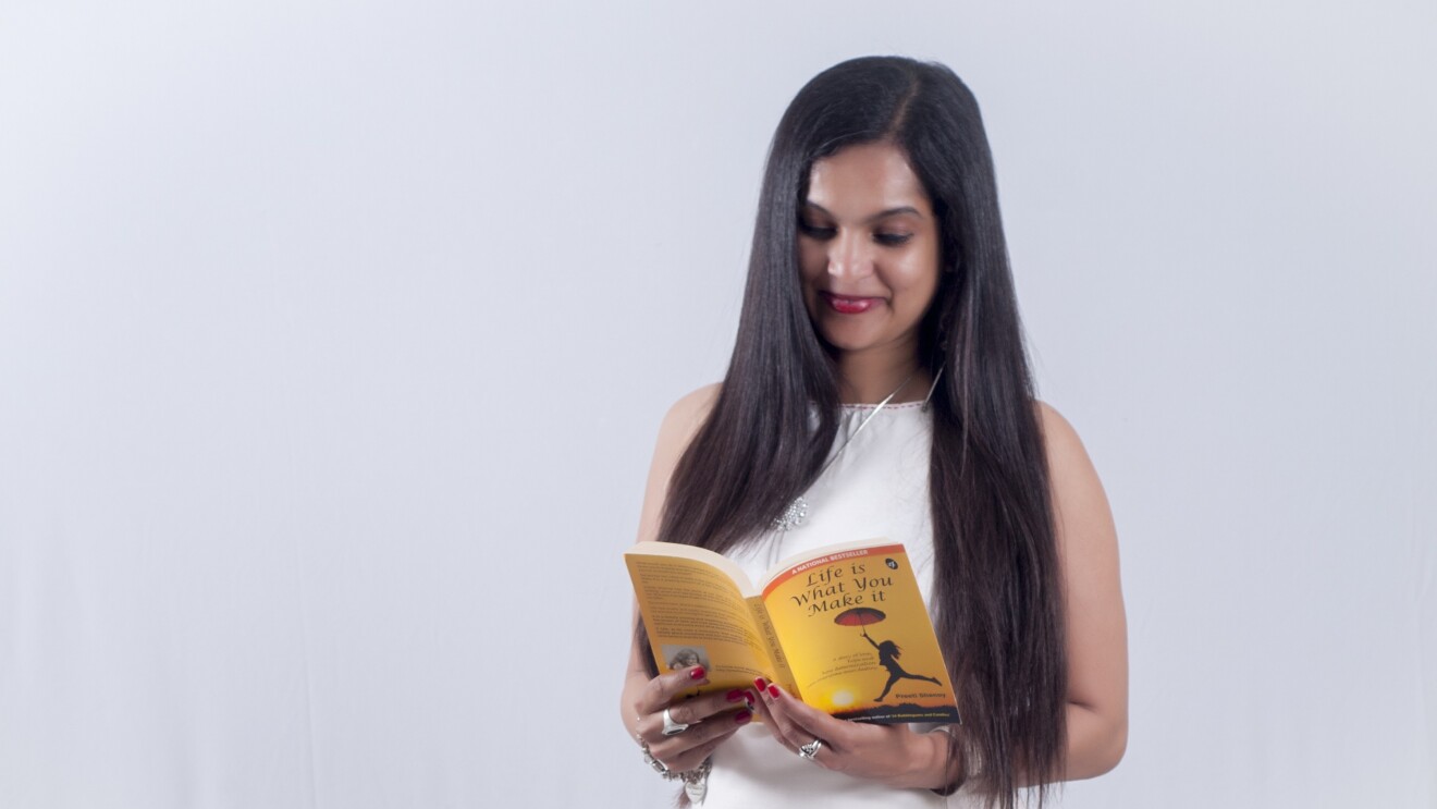 Author Preeti holds a book authored by her and is reading it