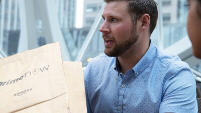 一名男子手持Prime Now套餐。