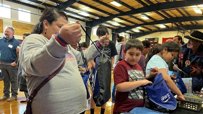 A photo of students receiving school supplies donated by AWS.