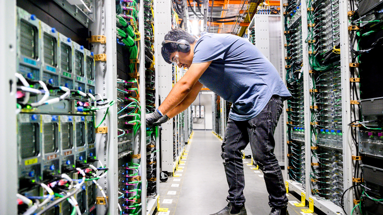 A technician inspecting a server in a data center.