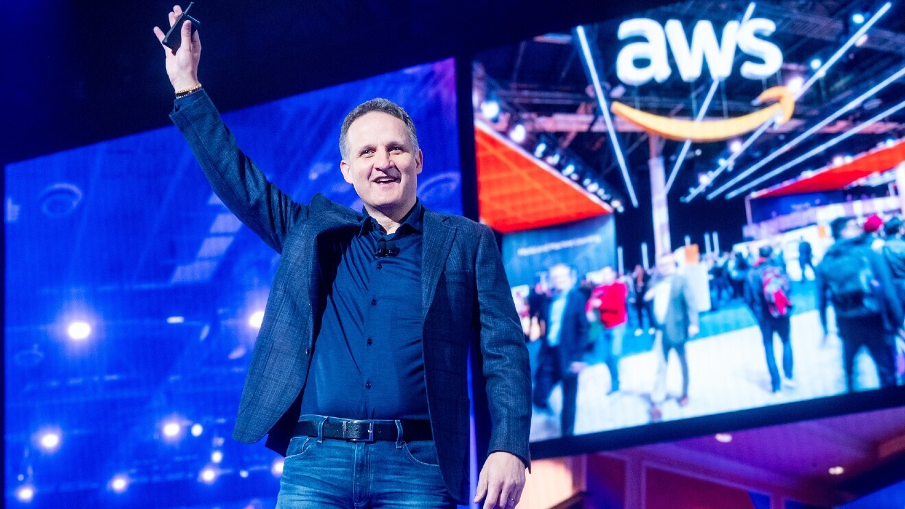 A photo of AWS CEO Adam Selipsky waving to an audience on stage at re:Invent 2022.