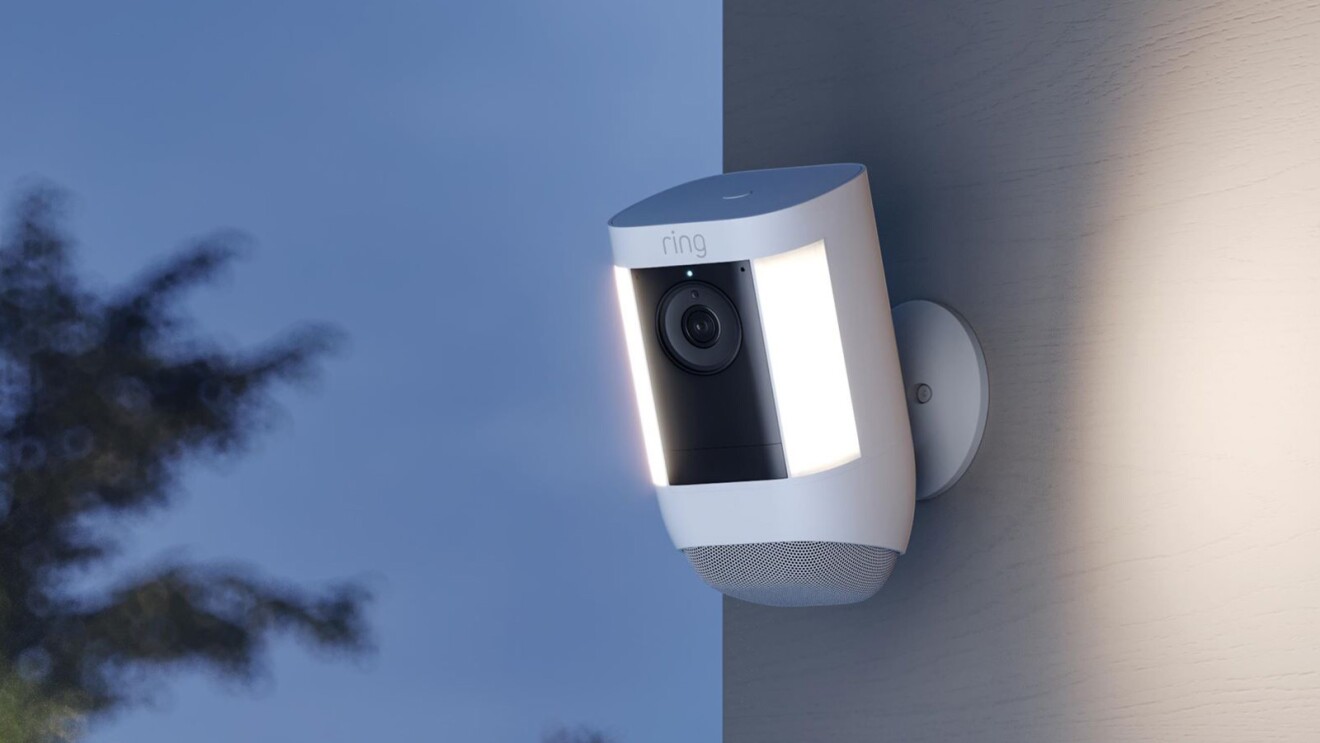 An illustration of a Ring camera hanging on a building wall outside.