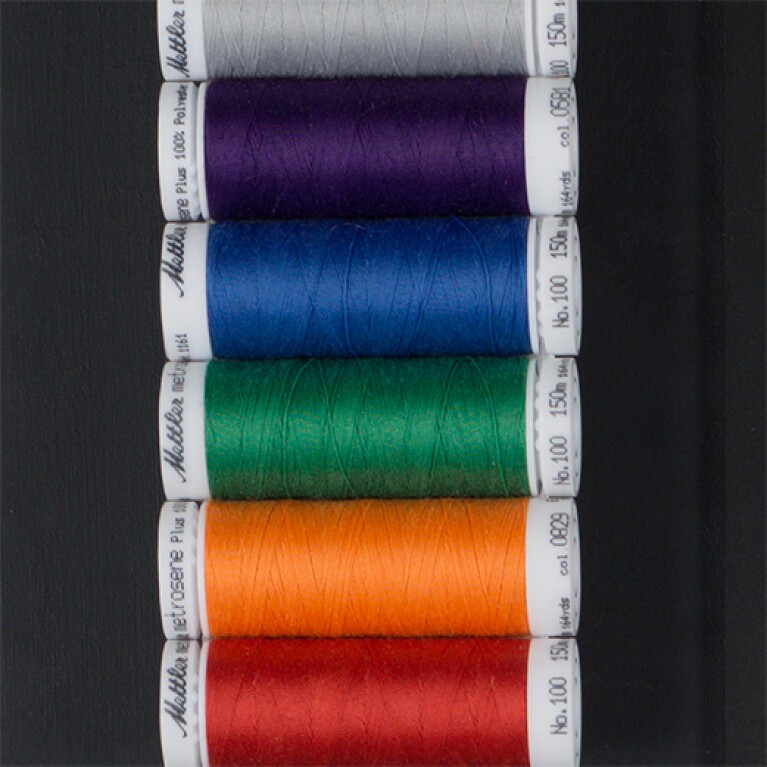 Spools of thread in a range of colors: gray, purple, blue, green, orange, and red.